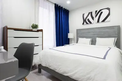 a bedroom with a bed and a desk with a chair at 75-1B NEW Prime Upper East W D Elevator in New York