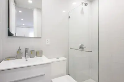 a white bathroom with a sink and a shower at 62-3A NEW Prime UES W D in unit Walk 2 C park in New York