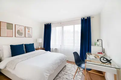 a bedroom with a bed and a desk and a window at 75-3C Brand New Duplex 3BR W D in the unit in New York