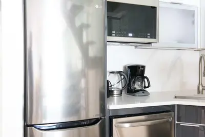 a kitchen with a stainless steel refrigerator and a microwave at 75-3C Brand New Duplex 3BR W D in the unit in New York