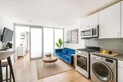 a kitchen with a blue couch in a room at 75-2D NEW Prime UES W&D Balcony Elevator in New York