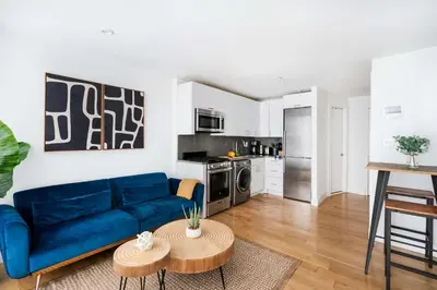 a living room with a blue couch and a table at 75-2D NEW Prime UES W&D Balcony Elevator in New York