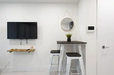 a room with two stools and a tv on a wall at 75-2C Furnished 1BR W D Elev WD Central park in New York