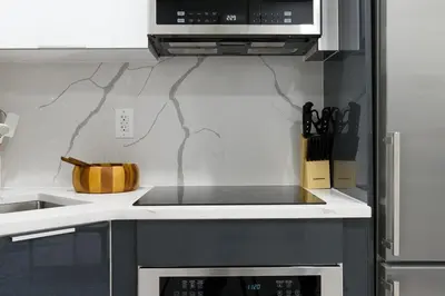a kitchen with a stove top oven and a microwave at 75-2C Furnished 1BR W D Elev WD Central park in New York