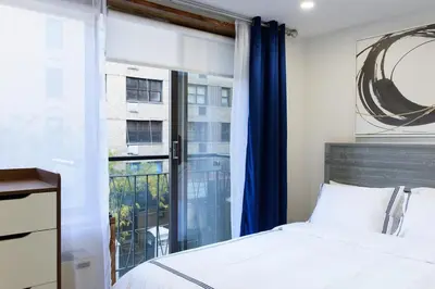 a bedroom with a bed and a large window at 75-2C Furnished 1BR W D Elev WD Central park in New York