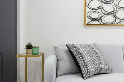 a white couch with a pillow and a side table at 75-2C Furnished 1BR W D Elev WD Central park in New York