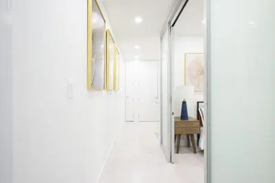 a hallway with white walls and a mirror at 75-3A 3Br Duplex Prime UES WD in unit Sleeps 6 in New York