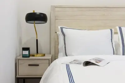 a bed with a black lamp and a book on it at 75-3A 3Br Duplex Prime UES WD in unit Sleeps 6 in New York
