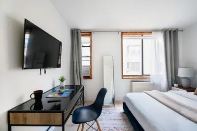 a hotel room with a bed and a desk and a television at 75-3B 3BR Luxury duplex BRAND NEW &D Elevator in New York