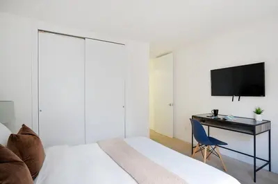 a bedroom with a bed and a desk with a television at 75-3B 3BR Luxury duplex BRAND NEW &D Elevator in New York