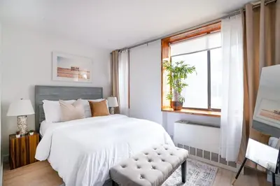 a white bedroom with a large bed and a window at 75-3B 3BR Luxury duplex BRAND NEW &D Elevator in New York