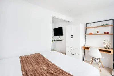 a white bedroom with a bed and a desk at 75-4A Brand new 3BR Prime UES W D in unit in New York