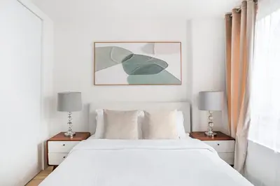 a bedroom with a white bed and two lamps at 75-4A Brand new 3BR Prime UES W D in unit in New York