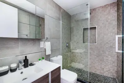 a bathroom with a shower and a toilet and a sink at 75-4A Brand new 3BR Prime UES W D in unit in New York
