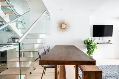 a dining room with a wooden table and stairs at 75-4A Brand new 3BR Prime UES W D in unit in New York