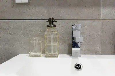 a glass bottle sitting on top of a bathroom sink at 75-4B Duplex 3BR Brand new W D Prime UES in New York
