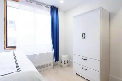 a bedroom with a white bed and a dresser at 75-5 Luxury 3BR Duplex W d Elevator bldg in New York
