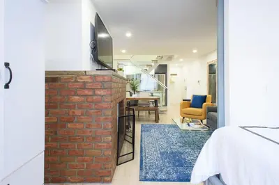 a bedroom with a brick wall and a living room at 75-5 Luxury 3BR Duplex W d Elevator bldg in New York