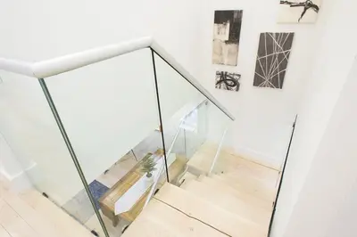 a staircase with glass railings in a house at 75-5 Luxury 3BR Duplex W d Elevator bldg in New York