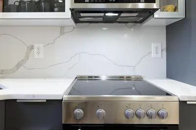a stove top in a kitchen with white counter tops at 75-5 Luxury 3BR Duplex W d Elevator bldg in New York