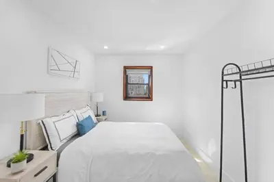 a white bedroom with a bed and a lamp at 75-5C 3BR LUXURY Duplex BRAND NEW W&D Elevator in New York