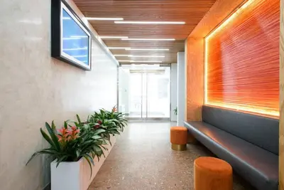 a waiting room with plants and a bench and a window at 75-5C 3BR LUXURY Duplex BRAND NEW W&D Elevator in New York