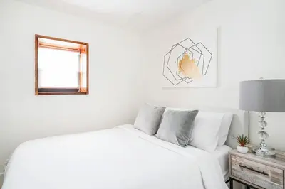 a white bedroom with a bed and a window at 75-4C New Duplex 3BR W D Elevator Walk to C park in New York
