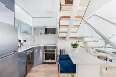 a kitchen with stainless steel appliances and stairs at 75-4C New Duplex 3BR W D Elevator Walk to C park in New York