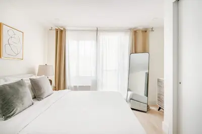 a white bedroom with a white bed and a window at 75-4C New Duplex 3BR W D Elevator Walk to C park in New York