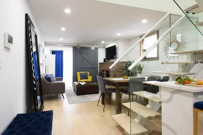 a kitchen and living room with a dining table and a staircase at 75-5D NEW Quality 3BR Duplex W&D Elevator in New York