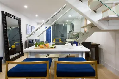 a kitchen with a table with blue chairs and stairs at 75-5D NEW Quality 3BR Duplex W&D Elevator in New York