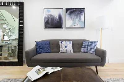 a living room with a couch and a mirror at 75-5D NEW Quality 3BR Duplex W&D Elevator in New York