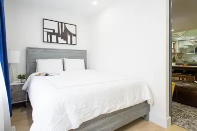 a bedroom with a large bed with white sheets at 75-5D NEW Quality 3BR Duplex W&D Elevator in New York