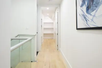 a hallway with a staircase and a painting on the wall at 75-5D NEW Quality 3BR Duplex W&D Elevator in New York