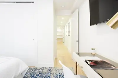 a white bedroom with a bed and a desk at 75-5D NEW Quality 3BR Duplex W&D Elevator in New York