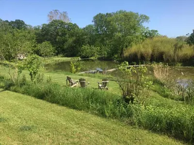 two benches sitting in the grass near a pond at Chestnut Hill Farm in Saugerties