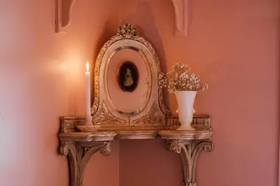 a mirror on a stand with a vase and candles at Chestnut Hill Farm in Saugerties