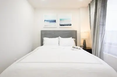 a white bed in a bedroom with a window at 75-5A Luxury 3BR Duplex W D in unit Elevator in New York