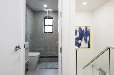 a bathroom with a toilet and a shower with a window at 75-5A Luxury 3BR Duplex W D in unit Elevator in New York