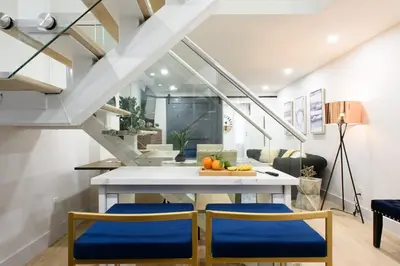 a kitchen with a white table and blue chairs at 75-5A Luxury 3BR Duplex W D in unit Elevator in New York