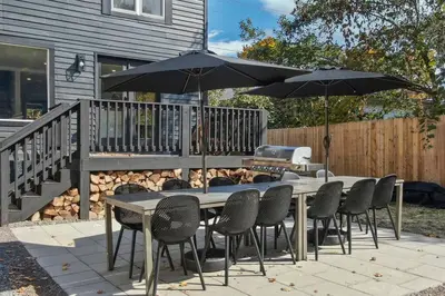 a table and chairs with umbrellas on a patio at Hunter Bungalow - Luxury Cabin, Kid-Friendly in Lanesville