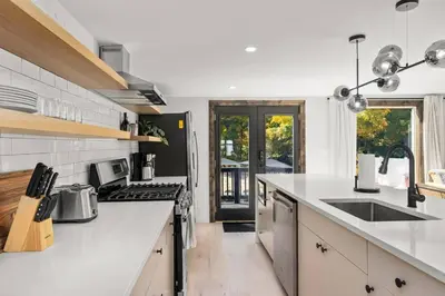 a kitchen with white counters and a stove top oven at Hunter Bungalow - Luxury Cabin, Kid-Friendly in Lanesville