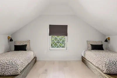 two beds in a white room with a window at Hunter Bungalow - Luxury Cabin, Kid-Friendly in Lanesville