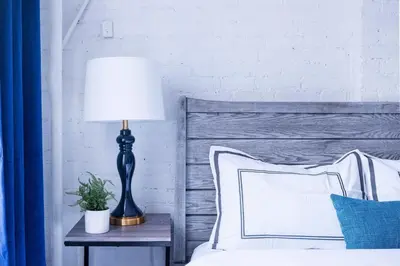 a bedroom with a bed with a lamp on a table at 83-2FE UES Central Park Newly Furnished Studio in New York