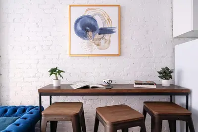 a table with two stools and a picture on a wall at 83-2FE UES Central Park Newly Furnished Studio in New York