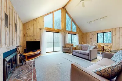 a living room with a fireplace and a tv at Farmhouse on the Road in Wilmington