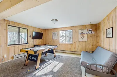 a room with a ping pong table and a couch at Farmhouse on the Road in Wilmington