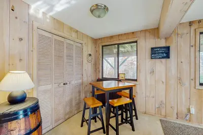a room with a table and stools in a room with wooden walls at Farmhouse on the Road in Wilmington