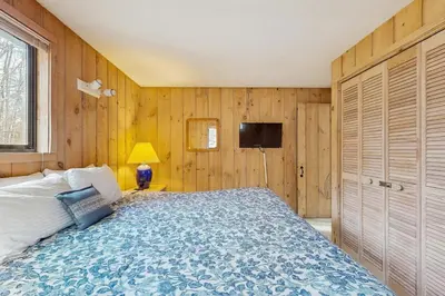 a bedroom with a bed and a tv on the wall at Farmhouse on the Road in Wilmington
