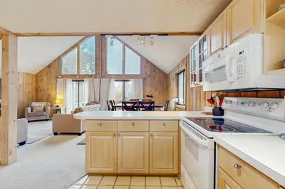a kitchen with white appliances and a living room at Farmhouse on the Road in Wilmington